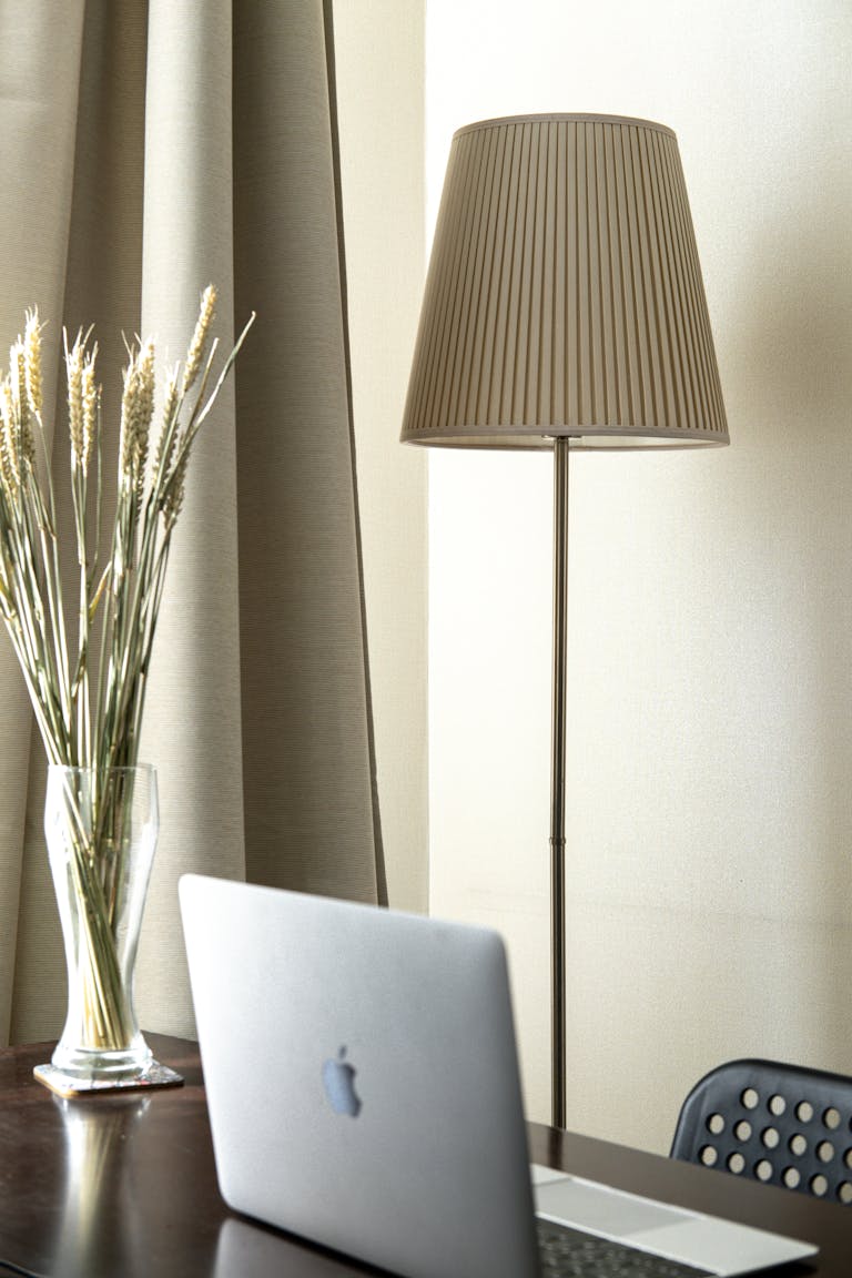 Elegant home office setup with a laptop, lamp, and decorative elements creating a modern and cozy atmosphere.